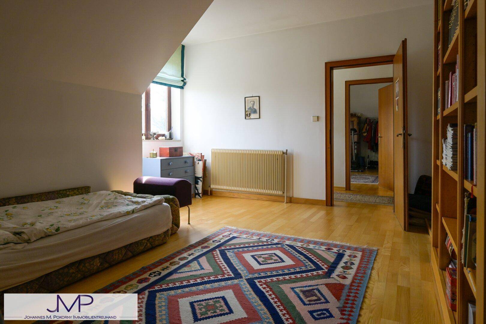 Helles Dachzimmer mit Holzboden, Fenster und Heizkörper, ideal als Schlaf- oder Gästezimmer.