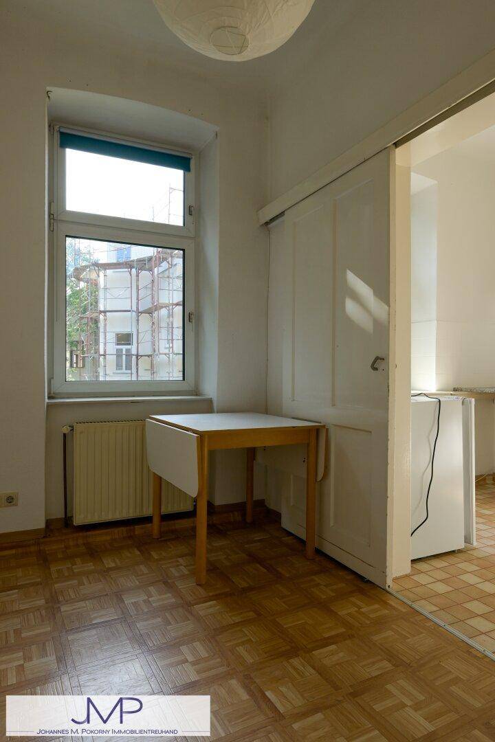 Kleiner Essbereich mit Holztisch und Parkettboden, angrenzend an die Küche, gemütlich und hell.