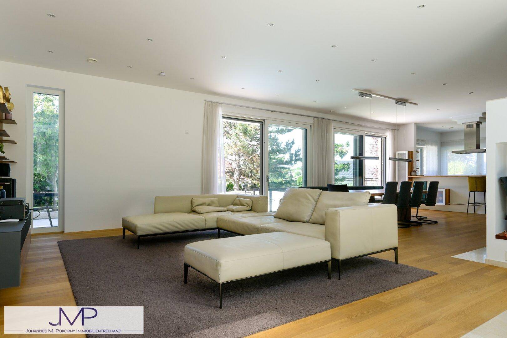 Offener Wohnbereich mit beiger Couch und Blick auf den Essbereich, hell und geräumig.