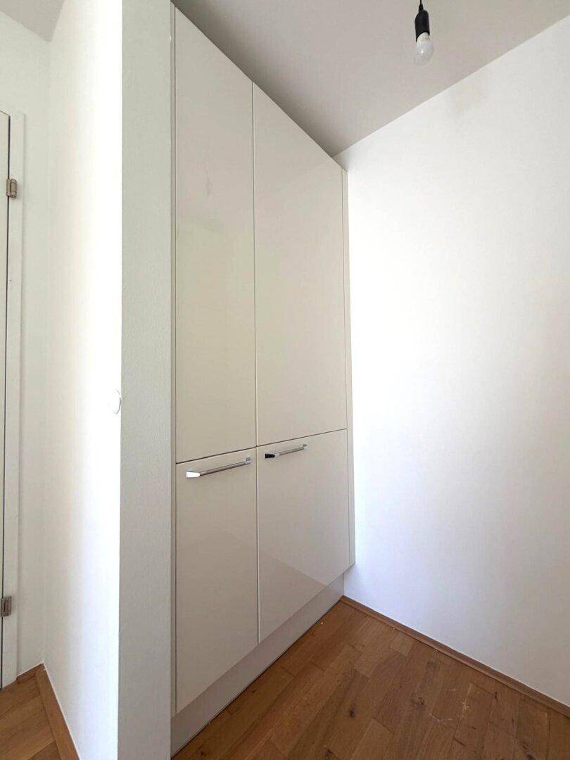 Integrierte weiße Schränke bieten zusätzlichen Stauraum in diesem funktionalen Bereich.