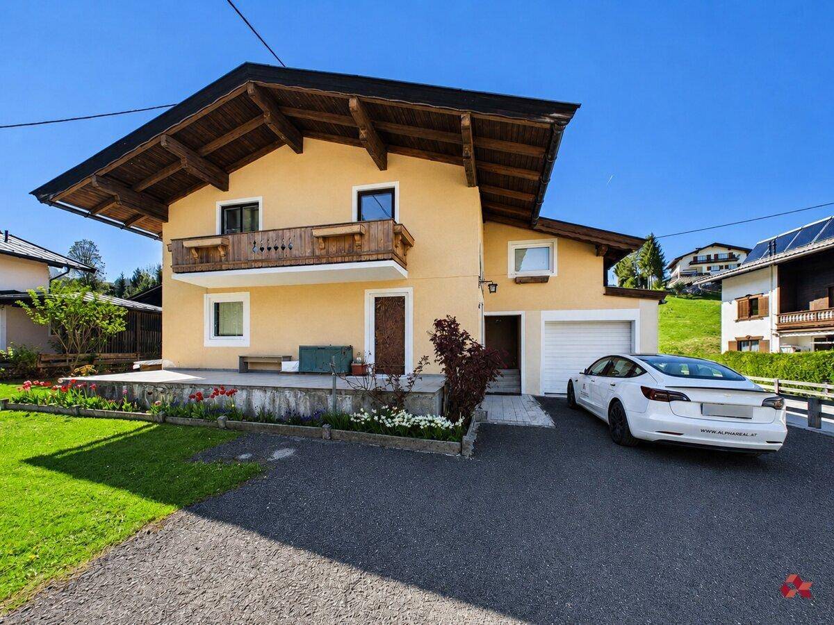 Charmantes Haus im Alpenstil mit Balkon, Garage und gepflegtem Vorgarten.