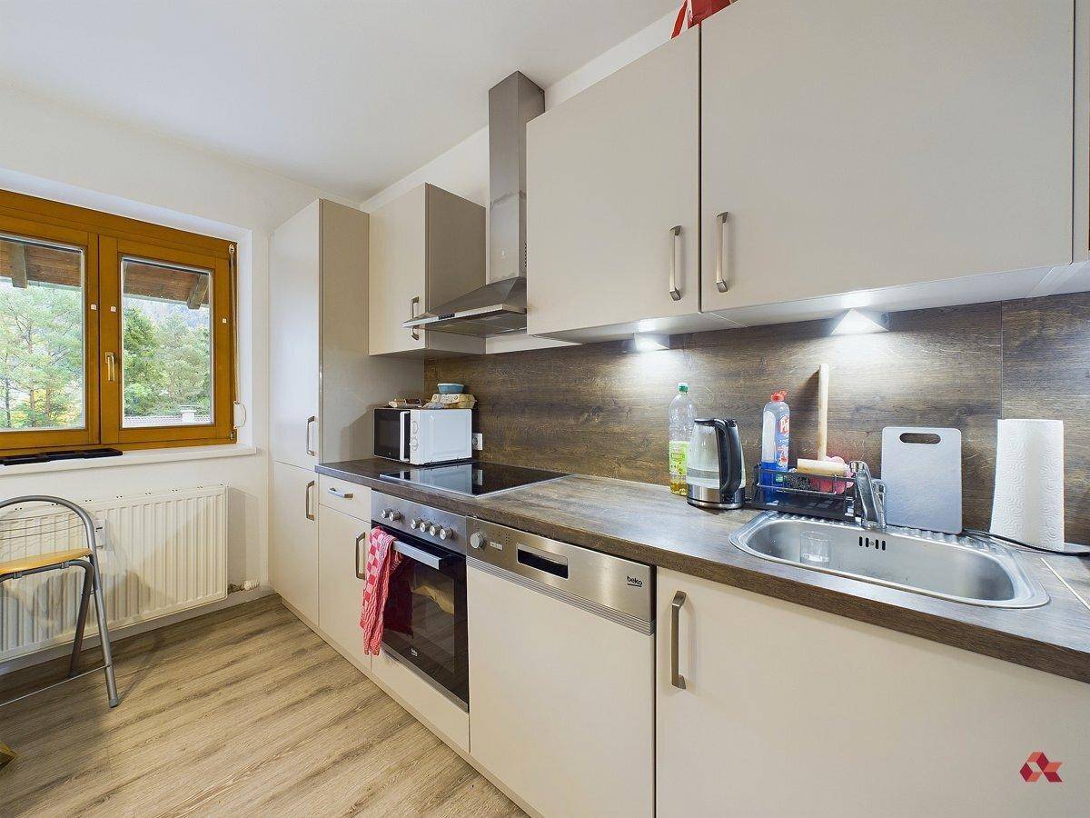 Funktionale Küche mit hellen Schränken, Holzoptik-Arbeitsplatte und modernen Geräten.