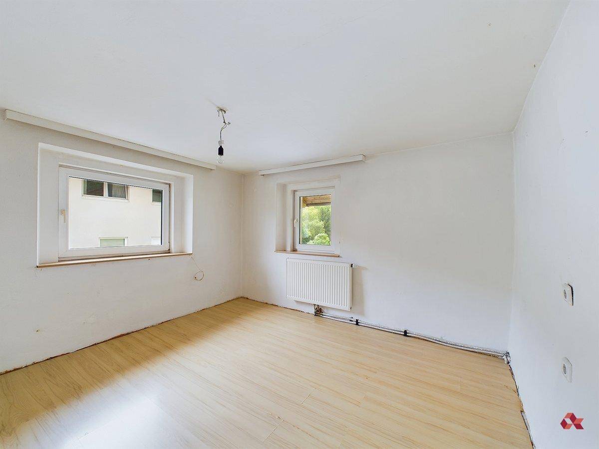 Helles Zimmer mit Laminatboden und zwei Fenstern, bietet viel Tageslicht.