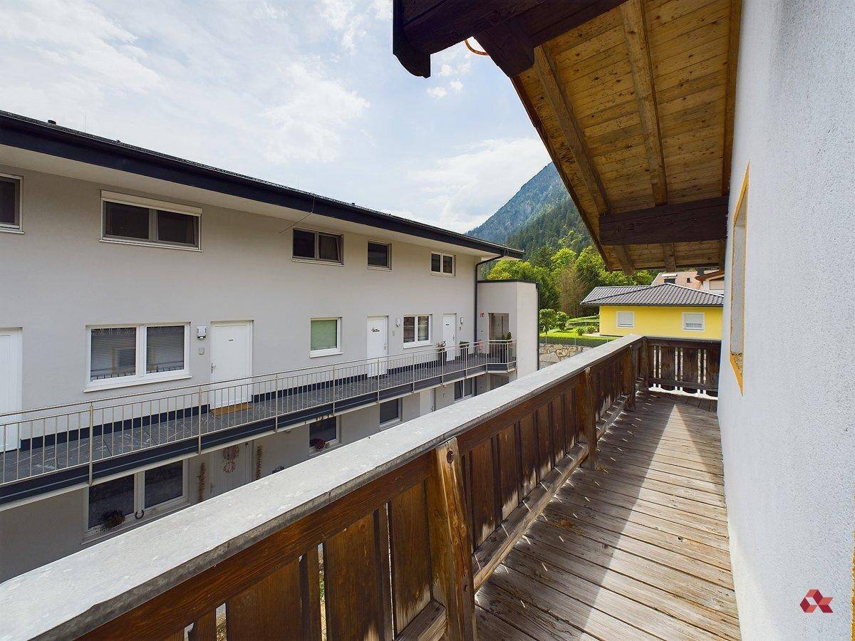 Holzbalkon mit Blick auf die umliegenden Gebäude und die Berglandschaft.