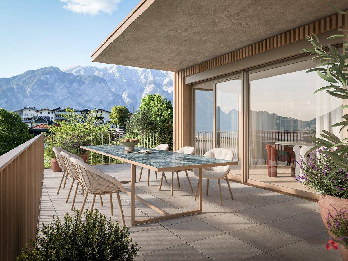 Geräumiger Balkon mit Esstisch und Stühlen, bietet einen weiten Blick auf die Berge.