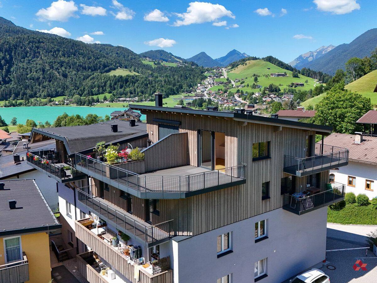 Gebäudeansicht von oben mit mehreren Balkonen und Terrassen, umgeben von Natur.