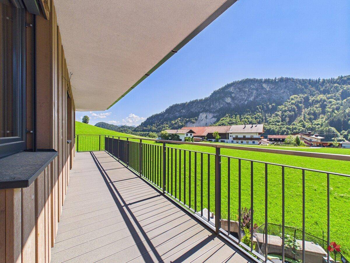 Langer Balkon mit weitem Blick über grüne Wiesen und die umliegende Naturlandschaft.
