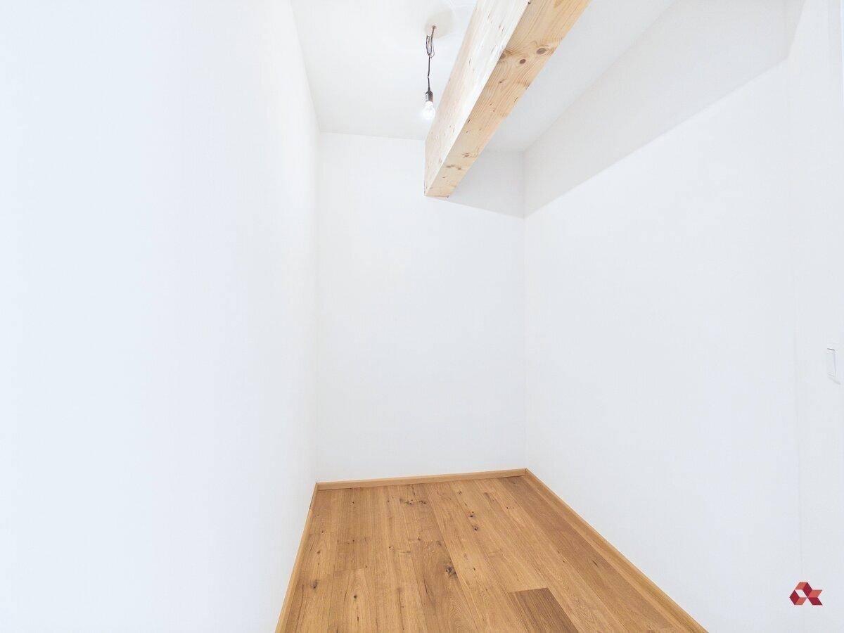 Kleiner, heller Abstellraum mit Holzbalken und Parkettboden, bietet zusätzlichen Stauraum.