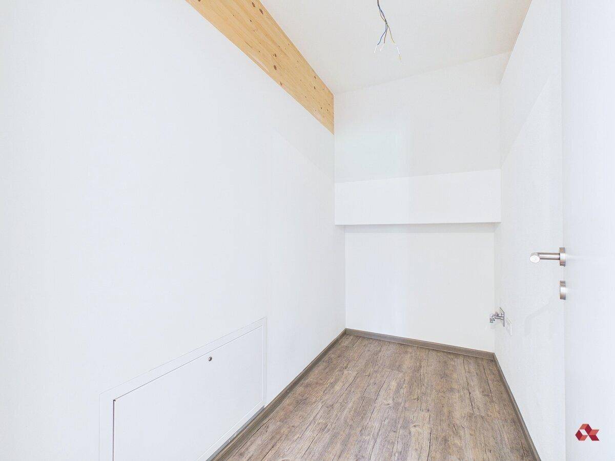 Kleiner Abstellraum mit Laminatboden und weiß gestrichenen Wänden, bietet praktischen Stauraum.