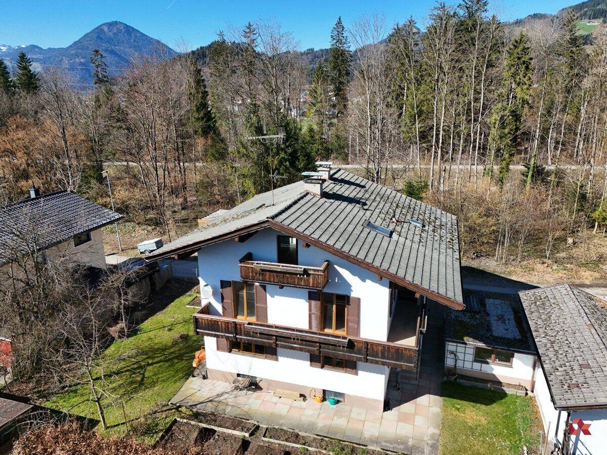 Luftaufnahme des Hauses mit Balkonen und Blick auf die bewaldeten Hügel.