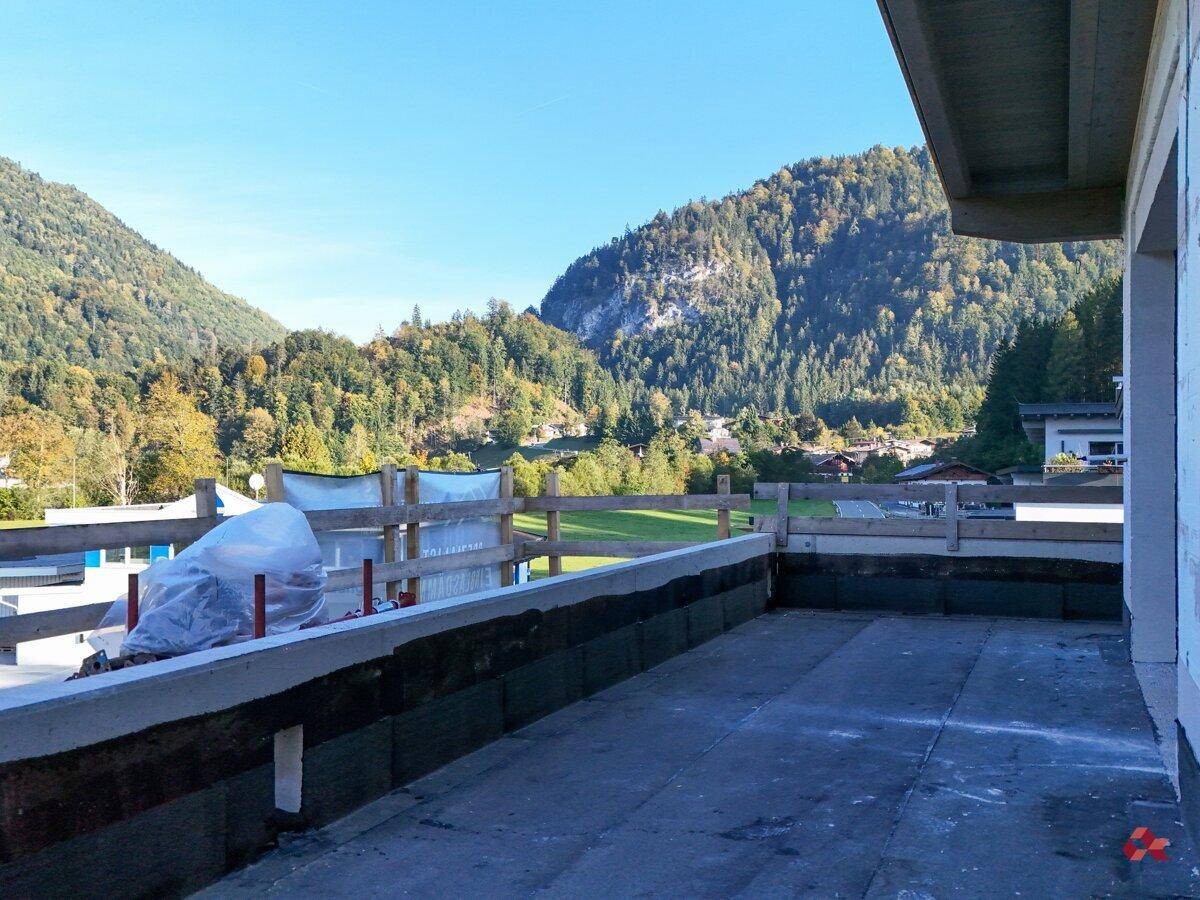 Unfertige Terrasse mit weitem Blick auf die umliegenden Berge und grüne Natur.