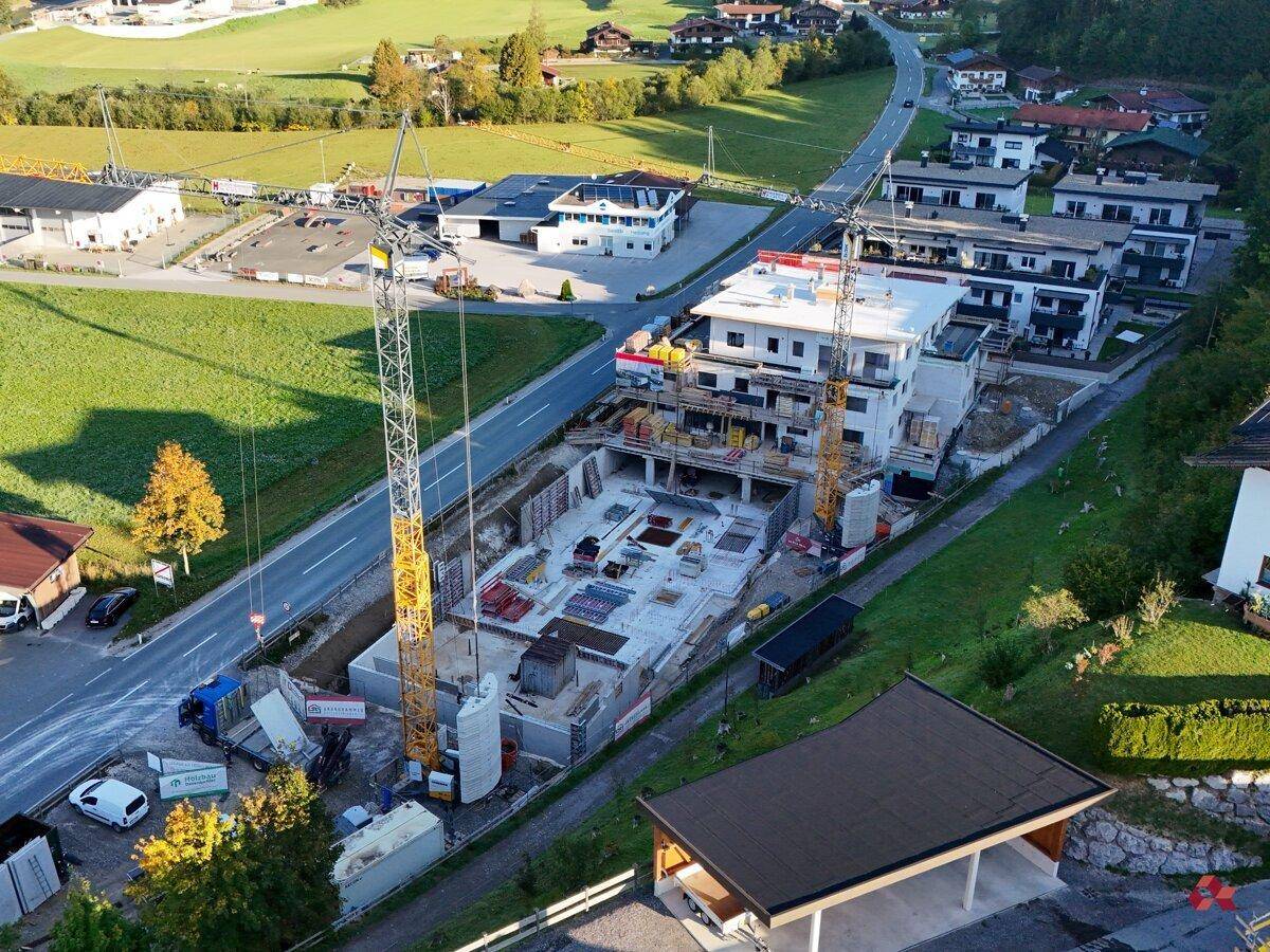 Luftaufnahme einer großen Baustelle mit Kränen und mehreren im Bau befindlichen Gebäuden.