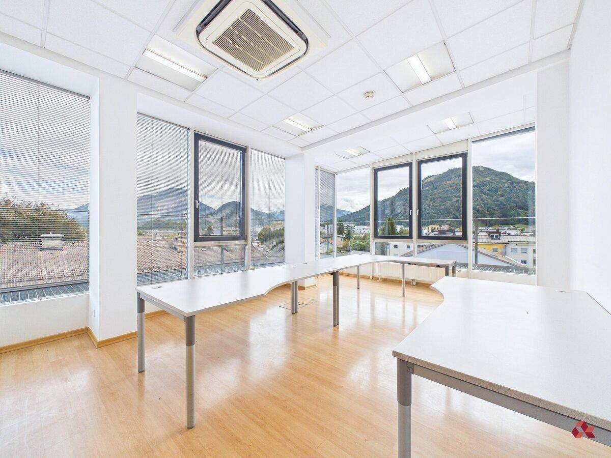 Weitläufiges Büro mit zahlreichen Fenstern, Klimaanlage und umfassendem Blick auf die Stadt und Berge.