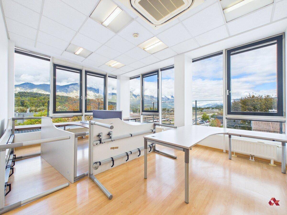 Großes Eckbüro mit vielen Fenstern, Klimaanlage und Panoramablick auf Berge und Umgebung.