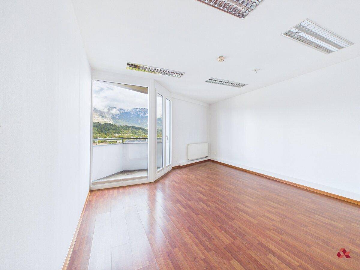 Lichtdurchfluteter Raum mit Holzboden, Bergblick und direktem Zugang zu einem Balkon.