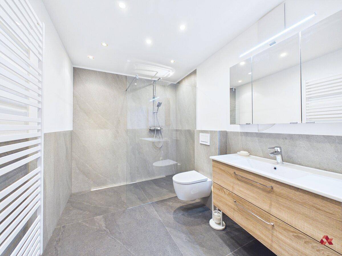 Modernes Badezimmer mit begehbarer Dusche, Wand-WC und Holzwaschtisch.