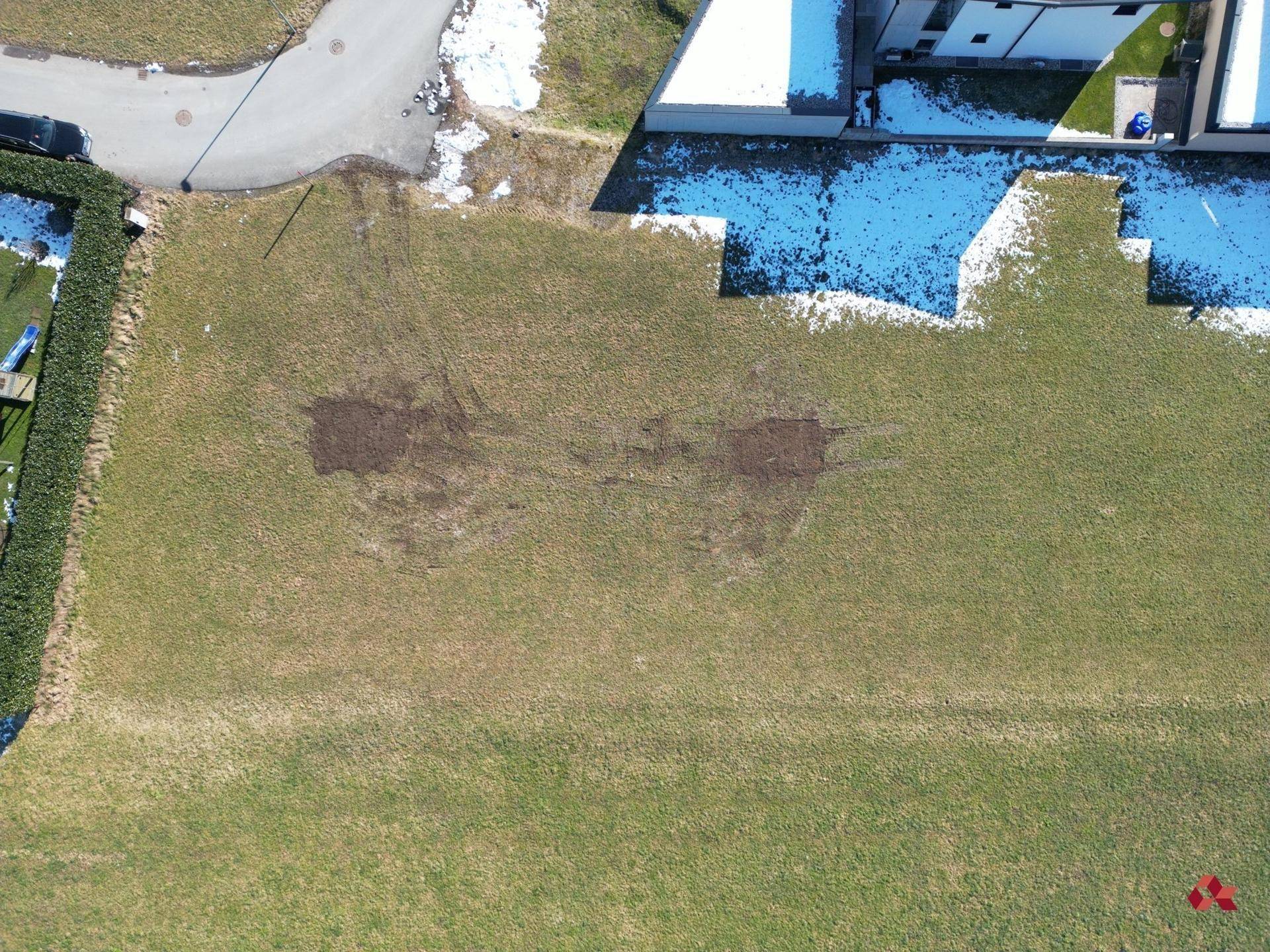 Luftaufnahme eines Grundstücks mit Rasenfläche und angrenzender Straße in ländlicher Umgebung.