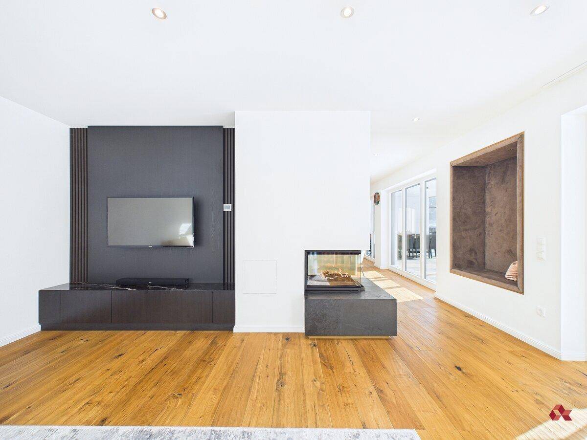 Wohnzimmer mit Holzboden, integriertem Kamin und moderner TV-Wand.