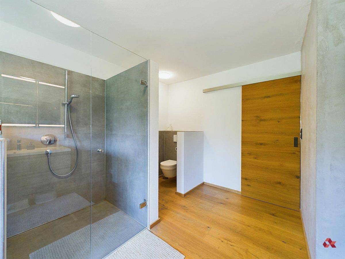 Helles Badezimmer mit geräumiger begehbarer Dusche und separatem WC-Bereich.