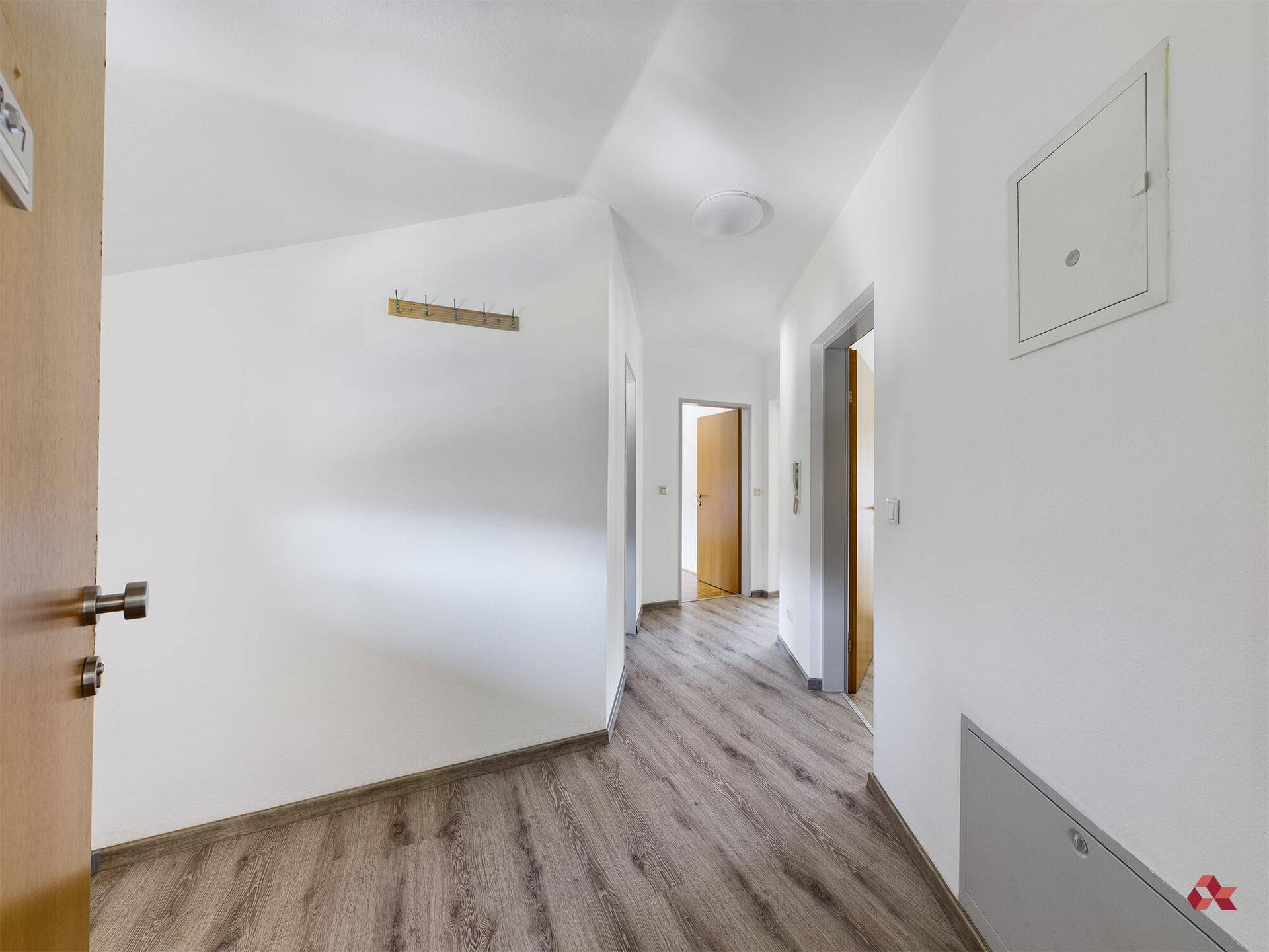 Heller Flur mit modernem Laminatboden und Zugang zu verschiedenen Räumen der Wohnung.