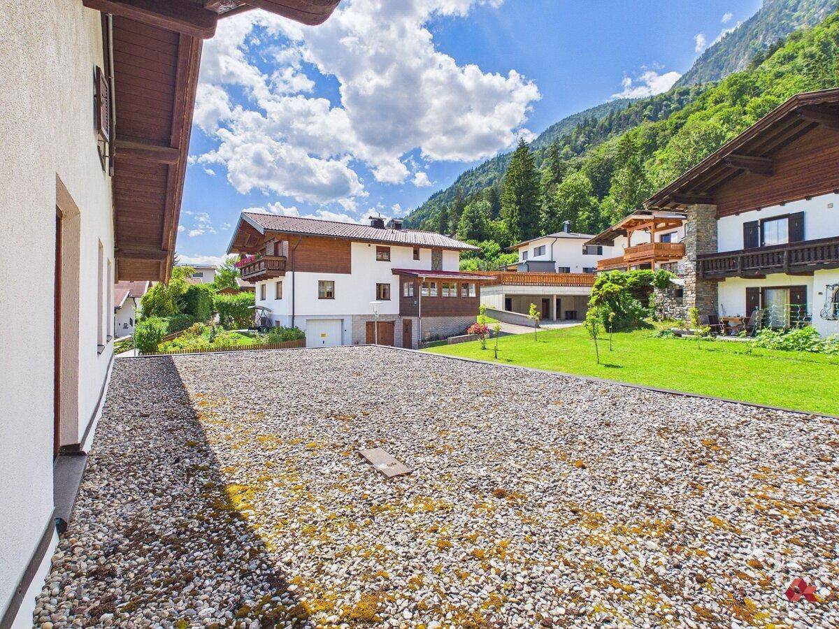 Große Kiesfläche neben dem Haus, möglicherweise eine ungenutzte Dachterrasse oder ein Flachdach.