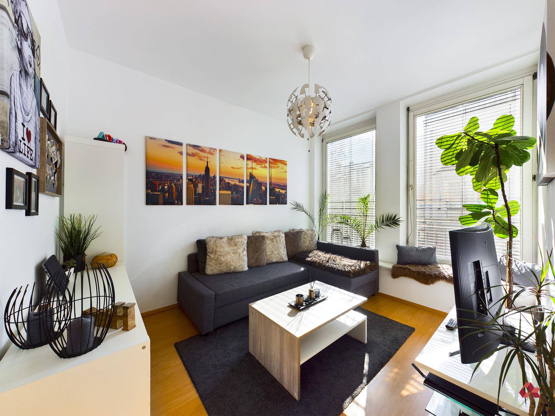 Gemütliches Wohnzimmer mit Sofa, Couchtisch und hellem Fensterplatz, modern dekoriert.