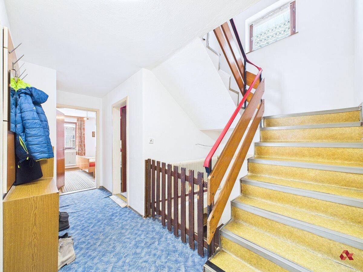 Eingangsbereich mit Treppe zum Obergeschoss und Garderobe.