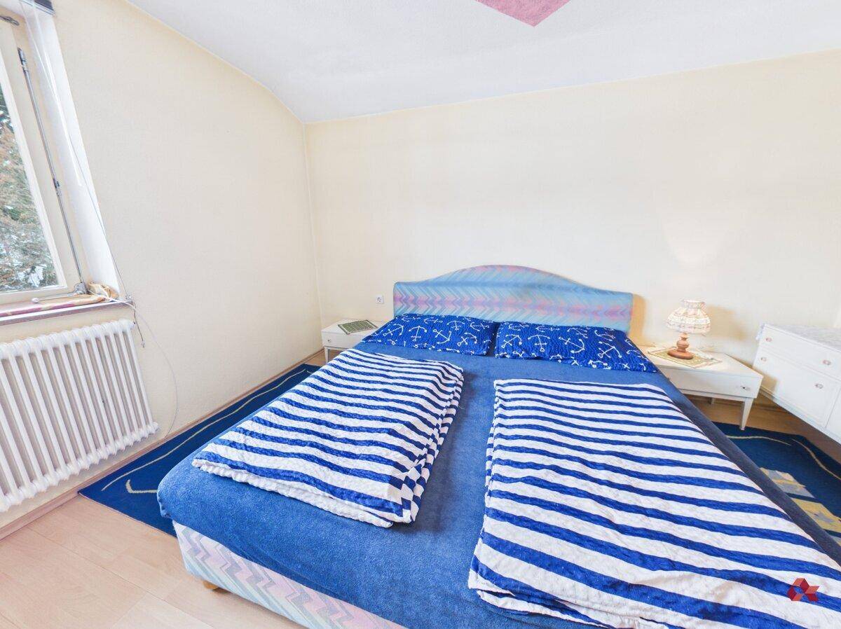 Gemütliches Schlafzimmer mit blauem Bett und passender Bettwäsche.