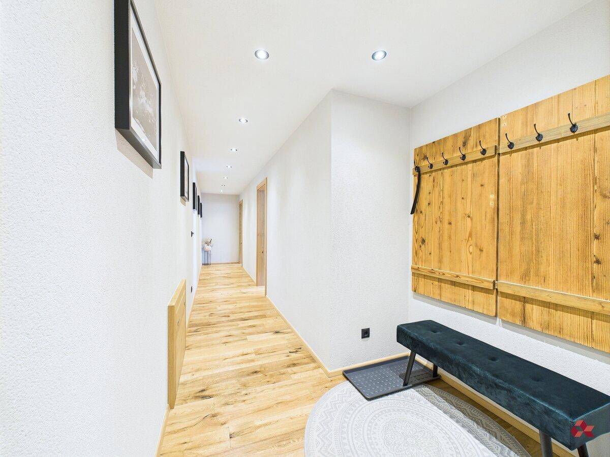 Heller Flur mit Holzboden und Garderobe, führt zu weiteren Räumen der Wohnung.