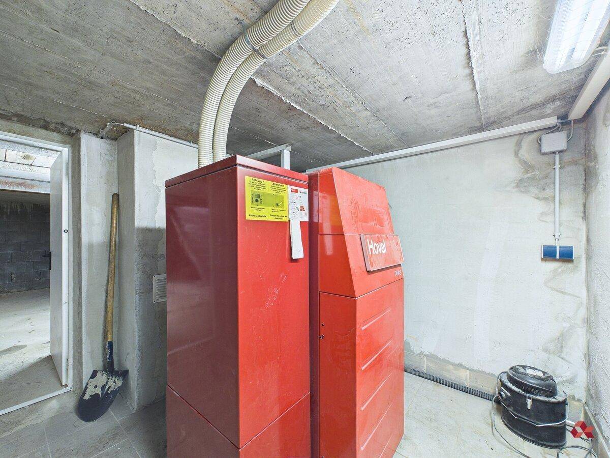Heizungsraum im Keller mit modernen Heizungsanlagen und technischen Installationen.