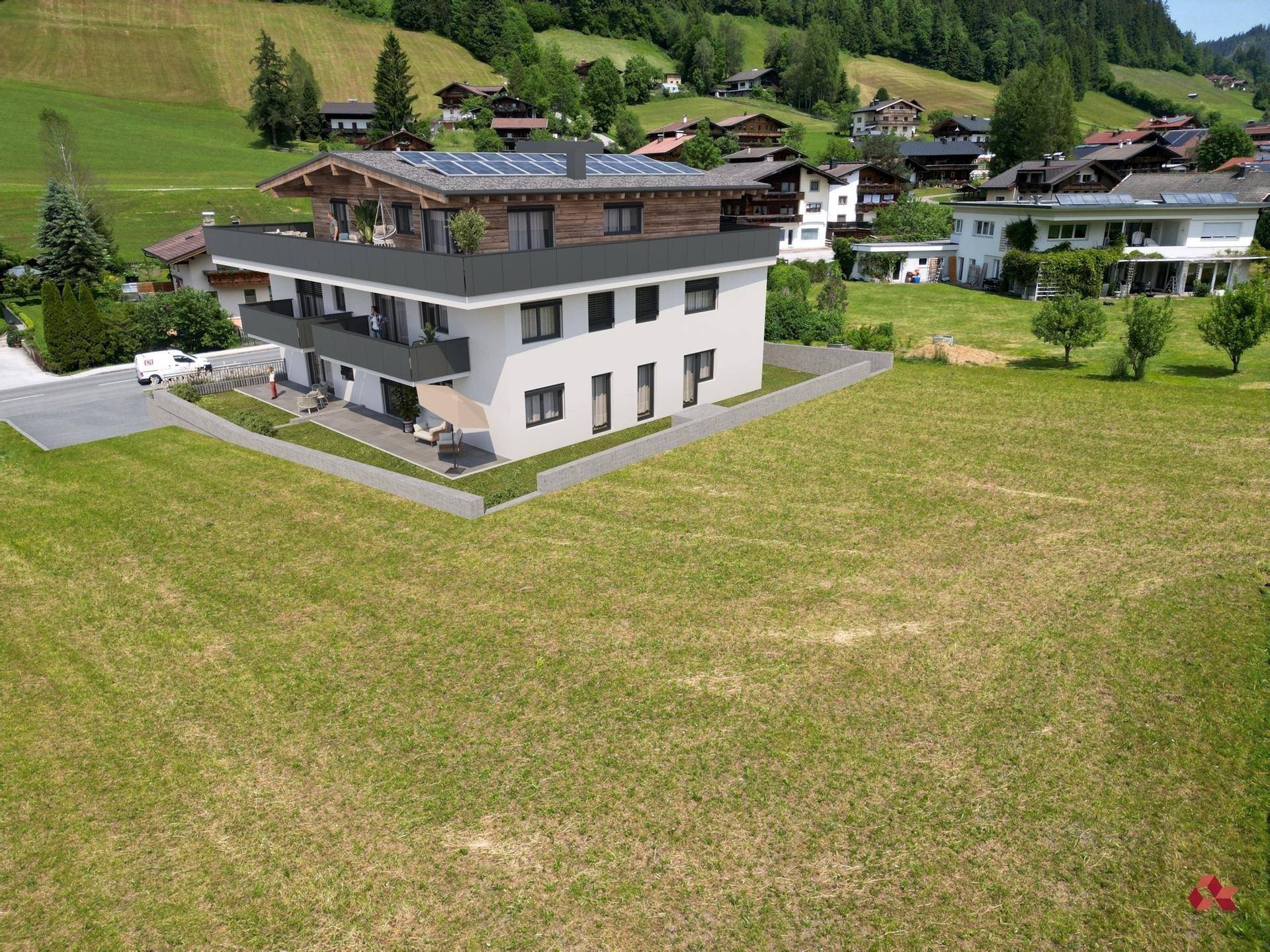 Moderne Wohnanlage in ländlicher Umgebung mit großzügigen Grünflächen und Bergblick.
