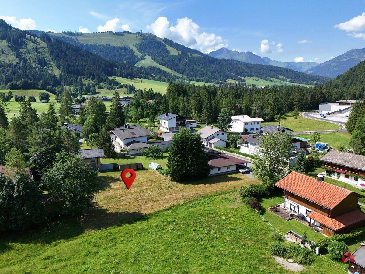 Panoramablick aus der Luft auf das Grundstück mit Markierung, eingebettet in eine Berglandschaft.