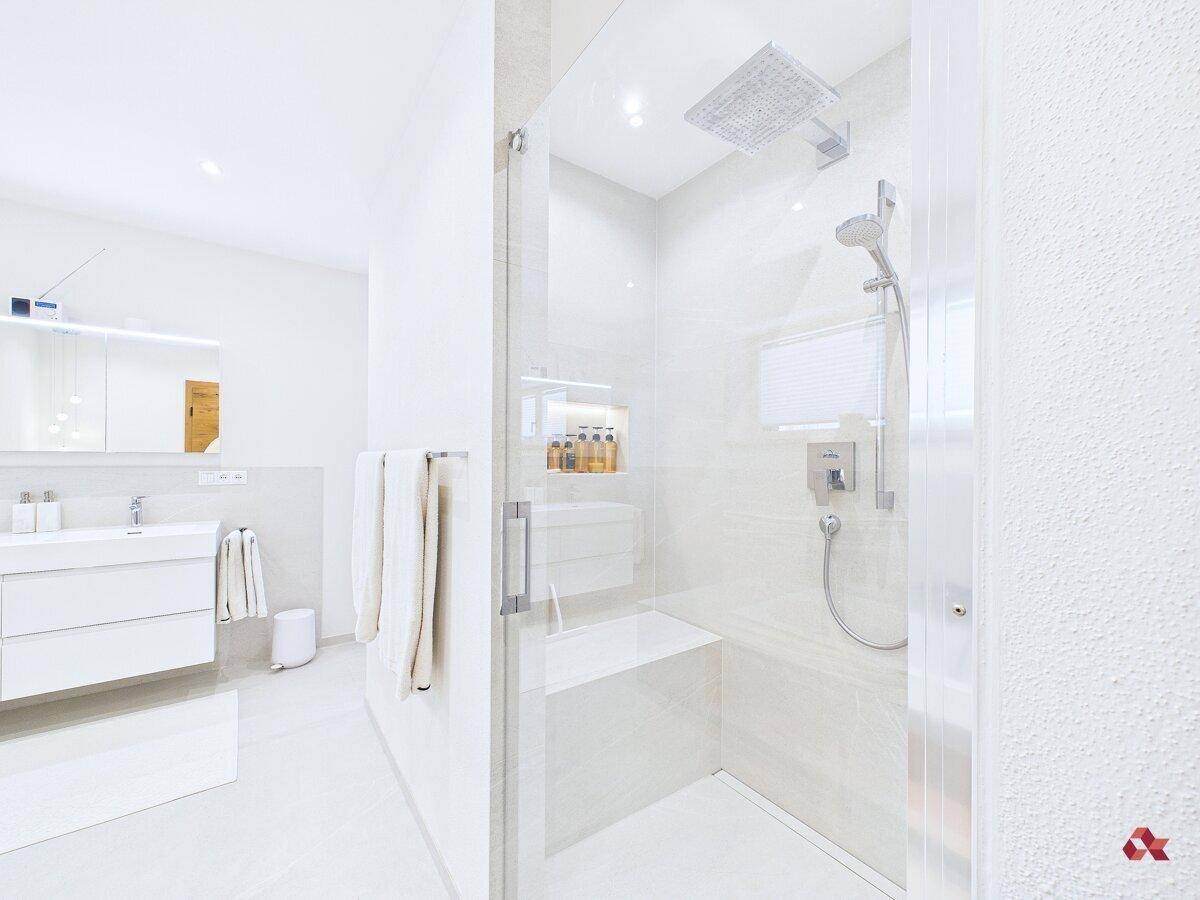 Elegantes Badezimmer mit begehbarer Dusche, Regendusche und modernen Armaturen.