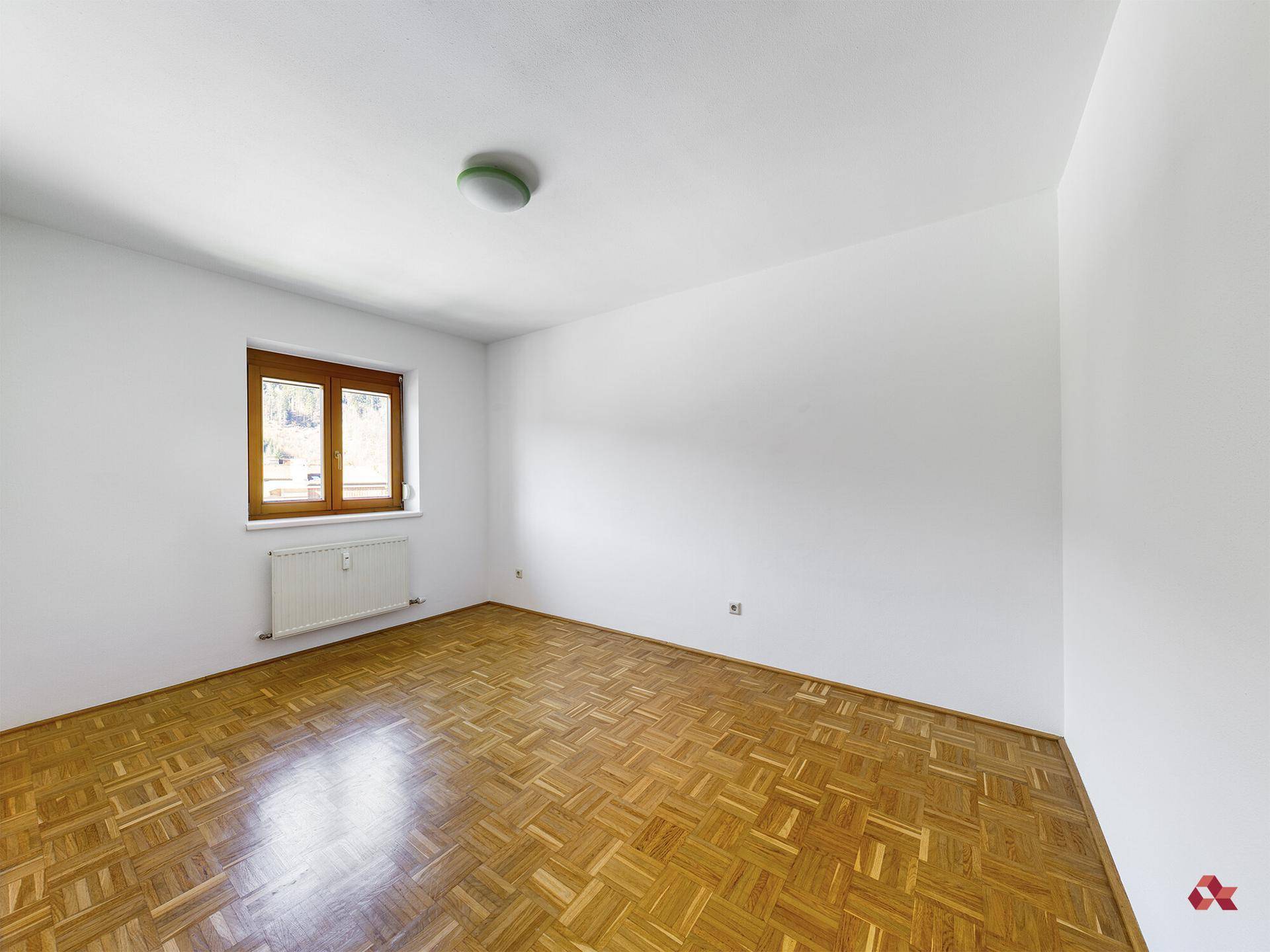 Leeres Schlafzimmer mit Parkettboden und Fenster, ideal für individuelle Einrichtungsideen.