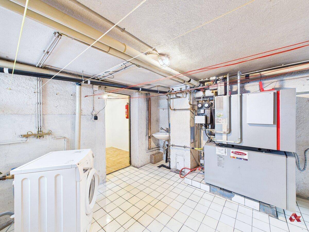 Heizungsraum mit Waschmaschine, Trockner und technischen Installationen.