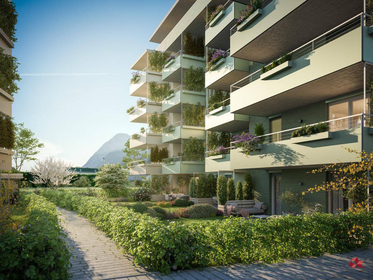 Begrünte Außenbereiche mit Gehwegen, Hecken und Balkonen an der modernen Wohnhausfassade.