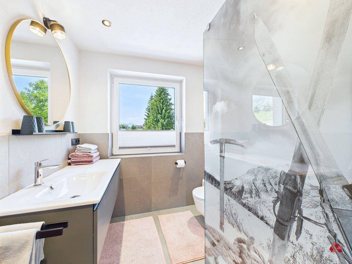Modernes Badezimmer mit Dusche, Einzelwaschbecken und Fenster, hell und funktional gestaltet.