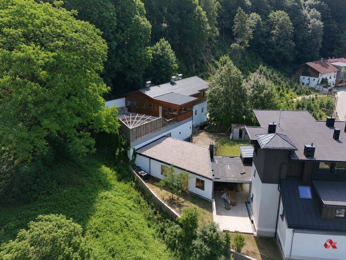 Überblick über das Anwesen mit mehreren Gebäuden und Außenbereichen in hügeliger Landschaft.