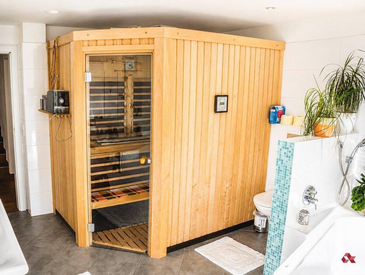 Modernes Badezimmer mit integrierter Sauna, Dusche und WC.