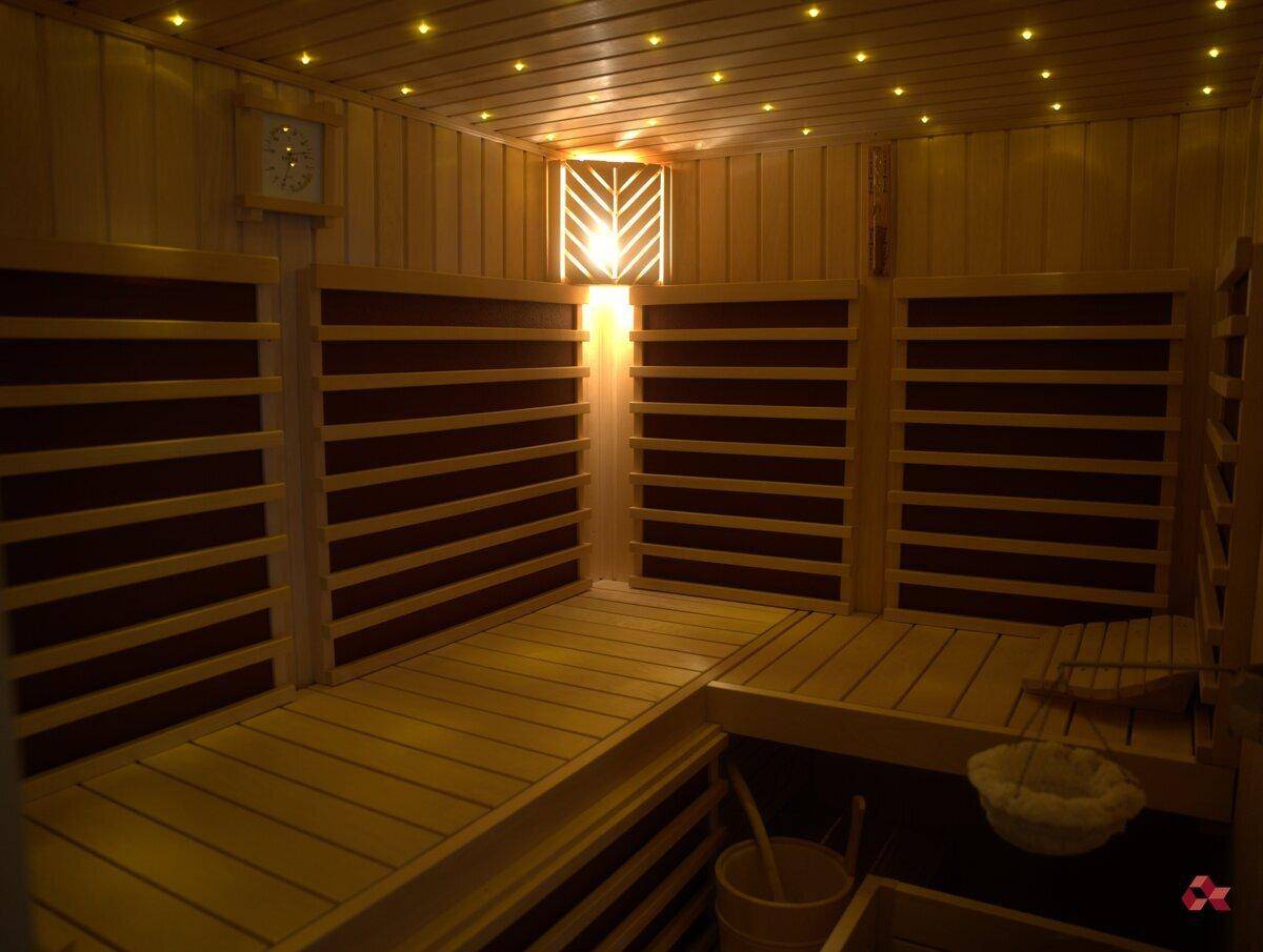 Gemütliche Holzsauna mit Bänken und stimmungsvoller Beleuchtung für Entspannung.