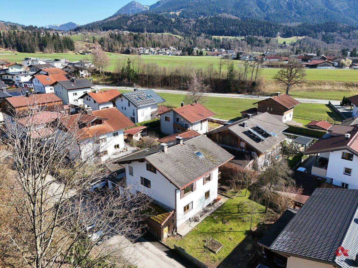 Weitläufige Luftaufnahme der Wohnsiedlung mit Häusern und grüner Landschaft im Hintergrund.