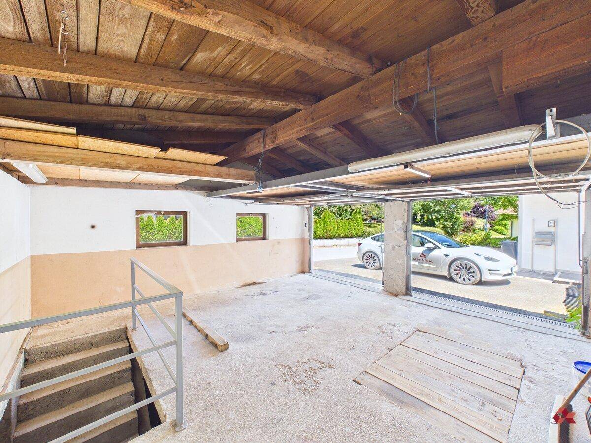 Geräumige Garage mit Holzbalkendecke und direktem Zugang zur Einfahrt.