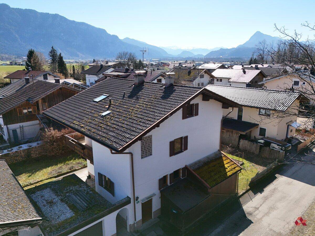 Luftaufnahme des Hauses in einer Wohnsiedlung mit Bergblick im Hintergrund.