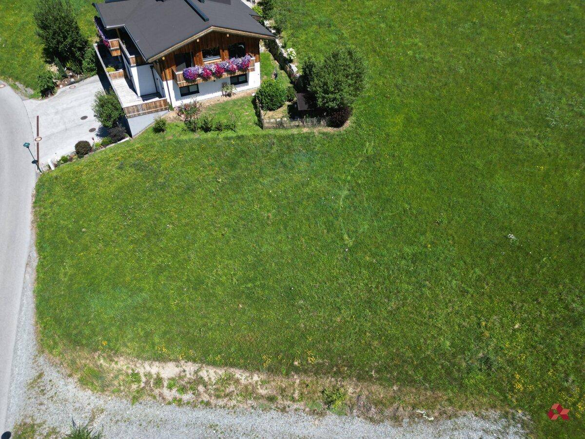 Luftaufnahme des Hauses und des angrenzenden großen Grundstücks in sonniger Hanglage.
