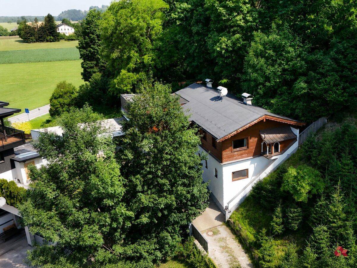 Luftaufnahme des Anwesens, eingebettet in grüne Natur mit Wald und Feldern.