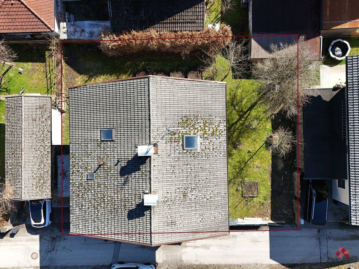 Draufsicht auf das Haus mit Garten und umliegenden Gebäuden, Grundstücksgrenzen markiert.