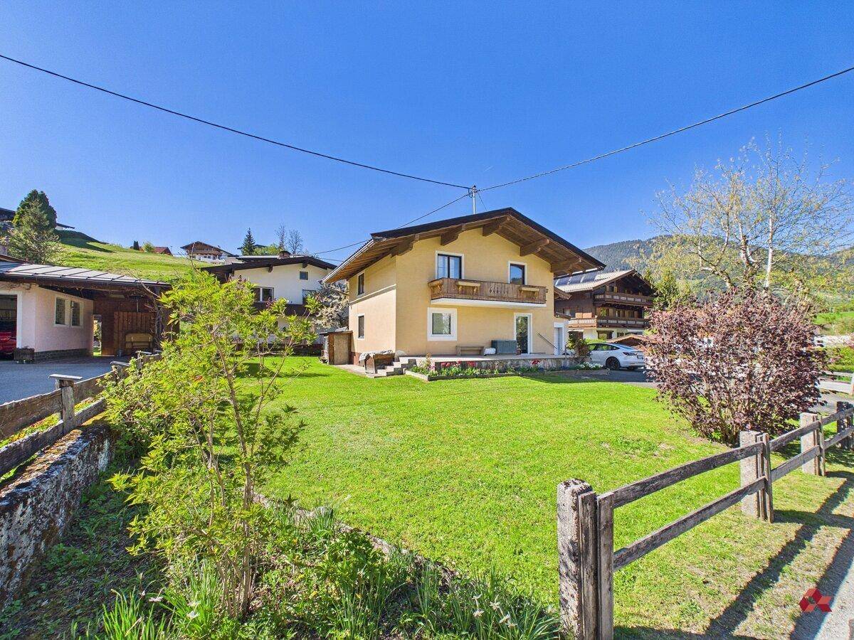 Freistehendes Haus mit großem Garten und Blick auf die umliegende Berglandschaft.