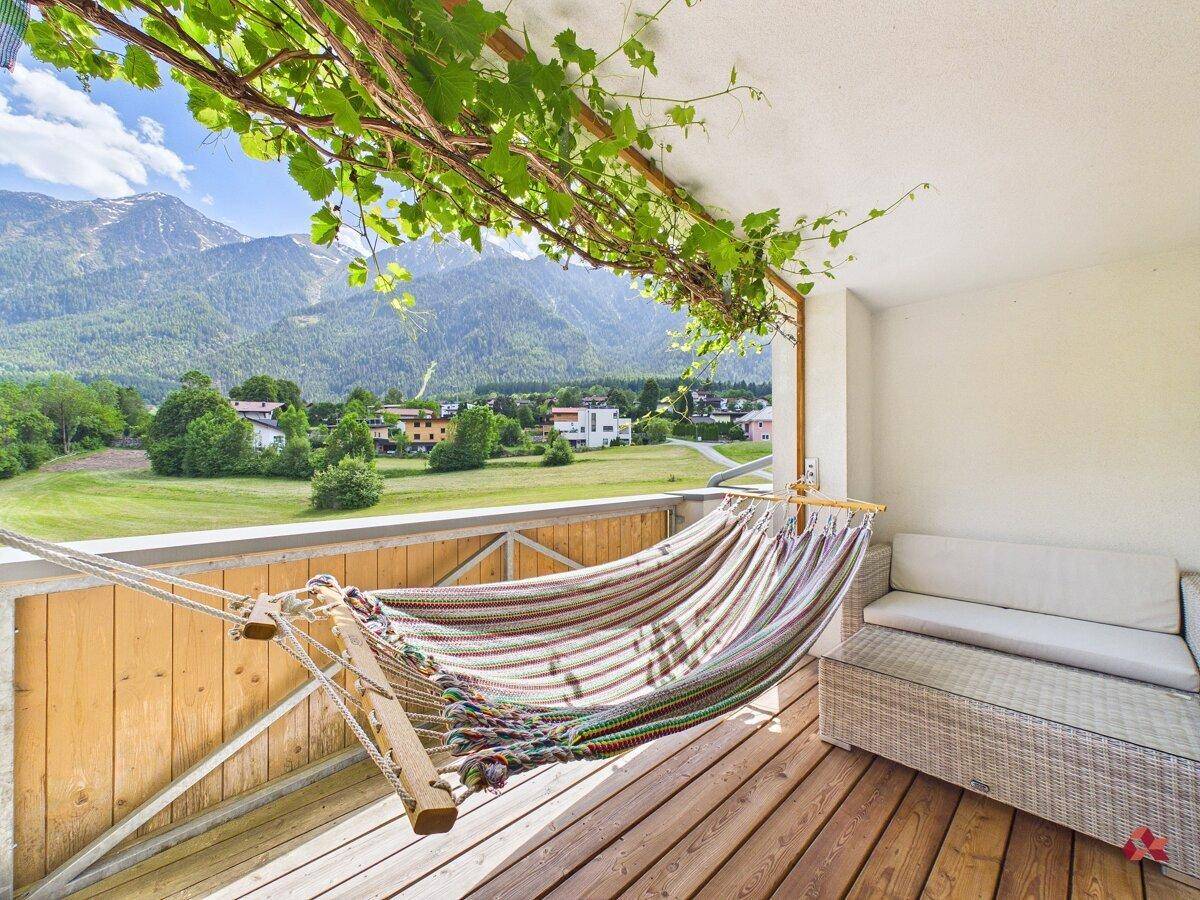 Gemütlicher Balkon mit Hängematte und Sofa, bietet einen herrlichen Bergblick.