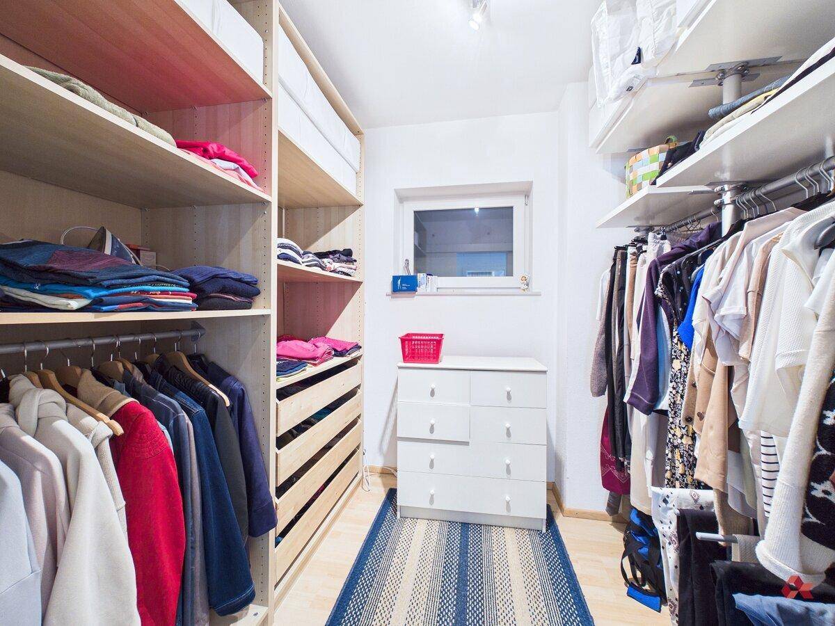 Geräumiger begehbarer Kleiderschrank mit Regalen, Schubladen und viel Stauraum.
