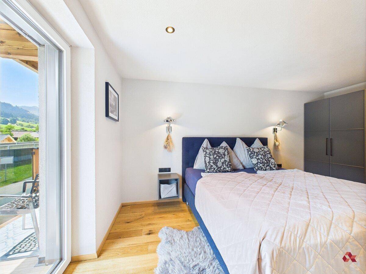 Schlafzimmer mit Zugang zum Balkon, Doppelbett und Kleiderschrank, bietet eine schöne Aussicht.